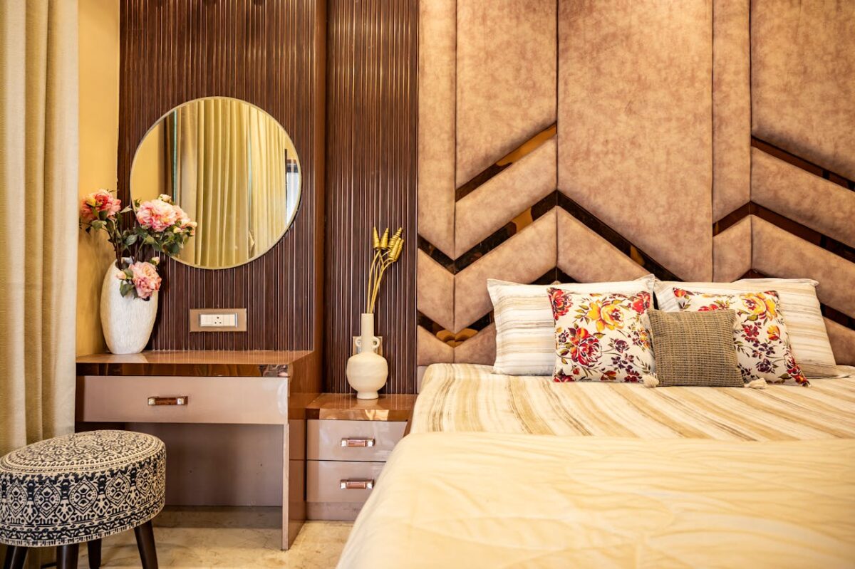 footer-cta-img Stylish bedroom interior featuring a cozy bed, floral pillows, and a chic vanity setup.